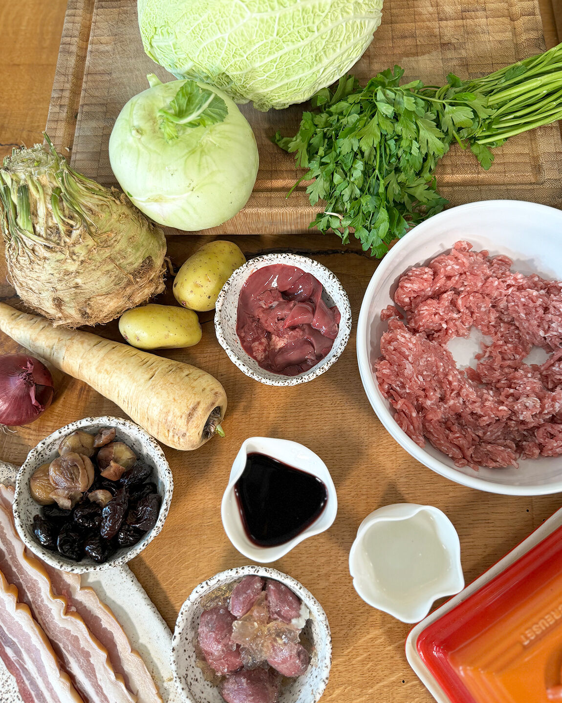 Ingrédients pour le chou farci : chou vert, légumes racines, viande hachée, lard, foie de volaille, pruneaux, marrons et vin rouge